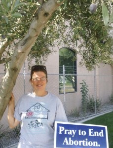 Terri stands under an olive tree outside new Planned Parenthood being constructed.